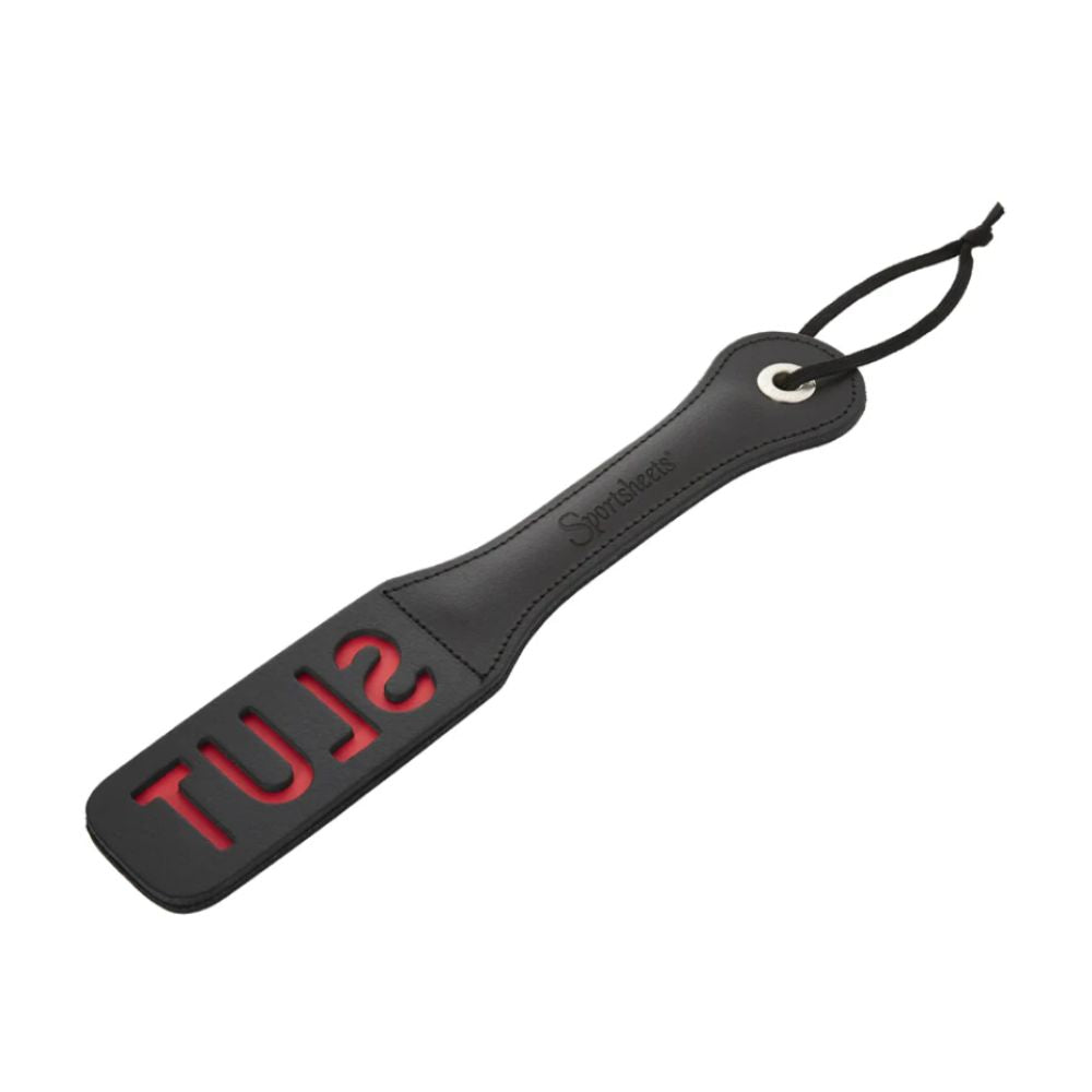 12 inch leather impression paddle by Sportsheets with “SLUT” cutout lettering, black and red BDSM accessory for impact play
